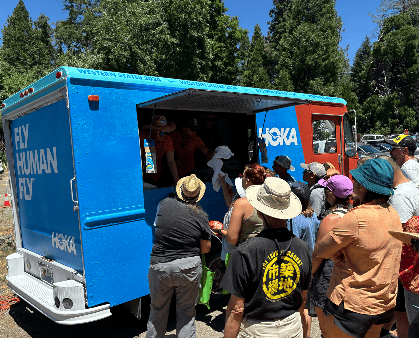 Enthusiastic guests at a concert waiting to get a live screen printed t-shirt from a mobile screen printing truck in San Diego, California.