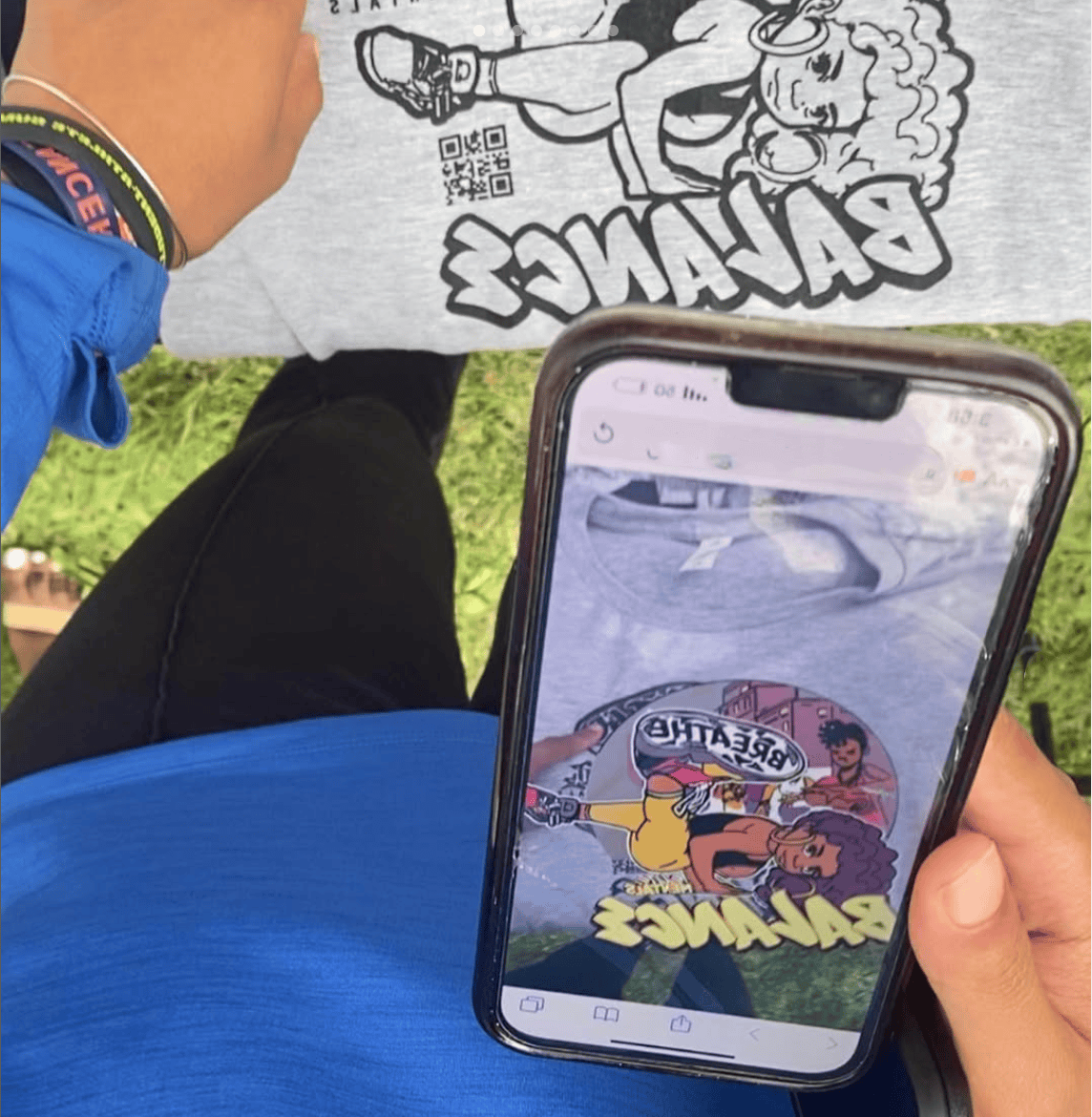 An excited guests of a marketing campaign scanning a one color image with her phone that uses augmented reality on a t-shirt design making it come to life in colorful 3D animation and music.