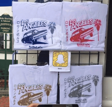 Excited people lining up at a mobile billboard pop up truck event that is live screen printing t-shirts with augmented reality graphics on the shirt in Los Angeles, California.