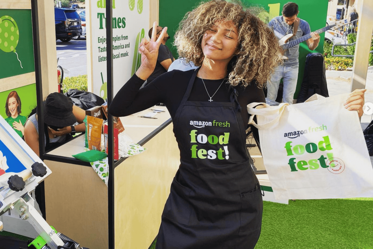 Person wearing an Amazon Fresh apron and holding a live onsite screen printed bag at an experiential marketing fest event for Amazon Stores.