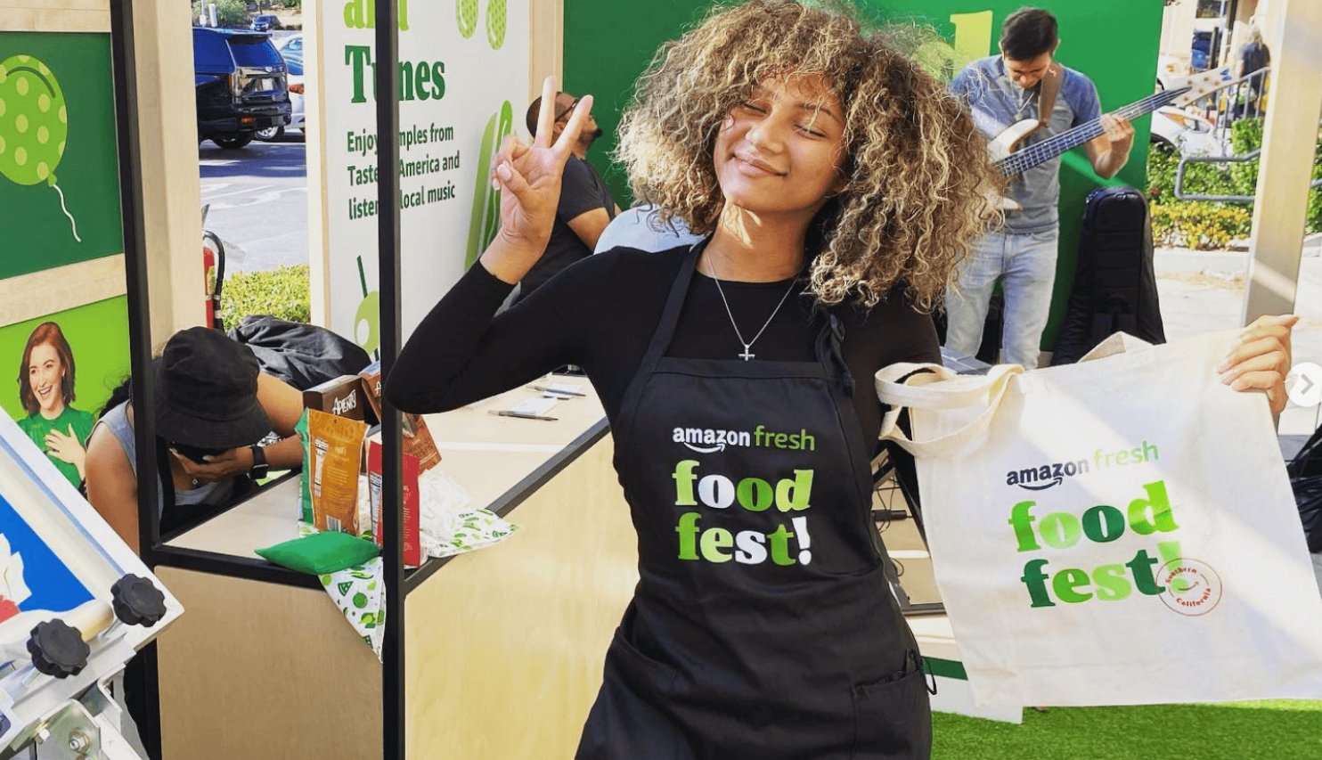 Person wearing an Amazon Fresh apron and holding a live onsite screen printed bag at an experiential marketing fest event for Amazon Stores.