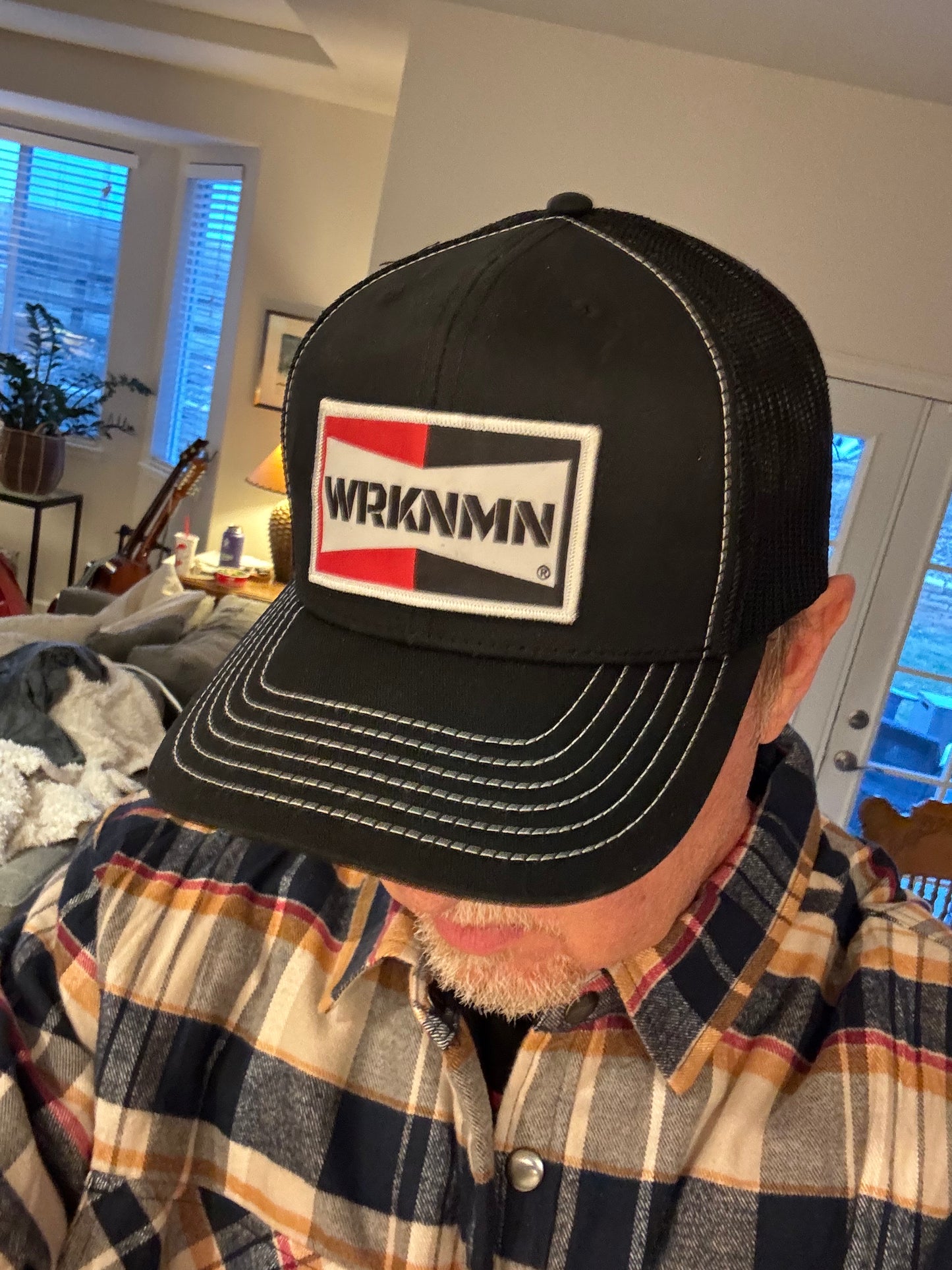 A hard working man wearing his classic WRKNMN truckers hat.