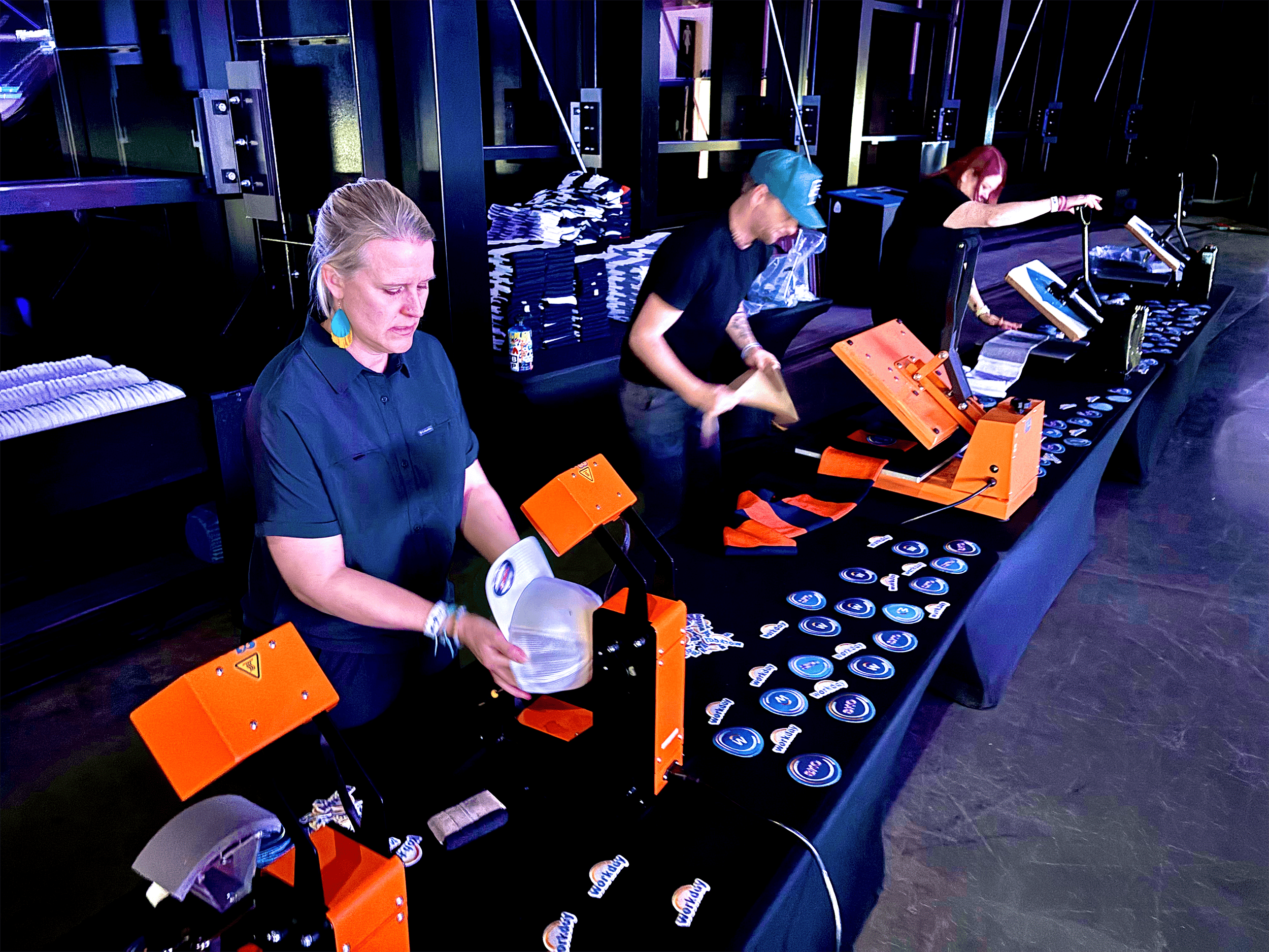 Three happy live printing technicians working a booth at the Las Vegas, Raiders Stadium tech conference and holiday party.  