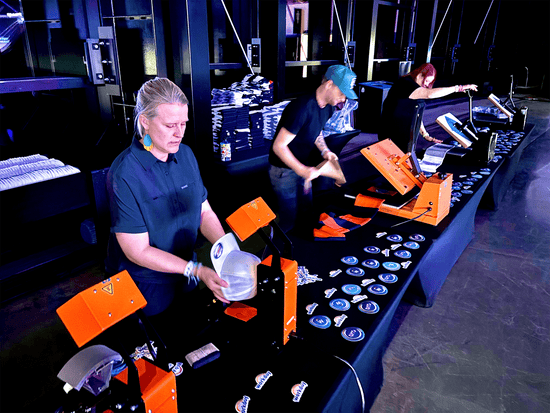 Three happy live printing technicians working a booth at the Las Vegas, Raiders Stadium tech conference and holiday party.  