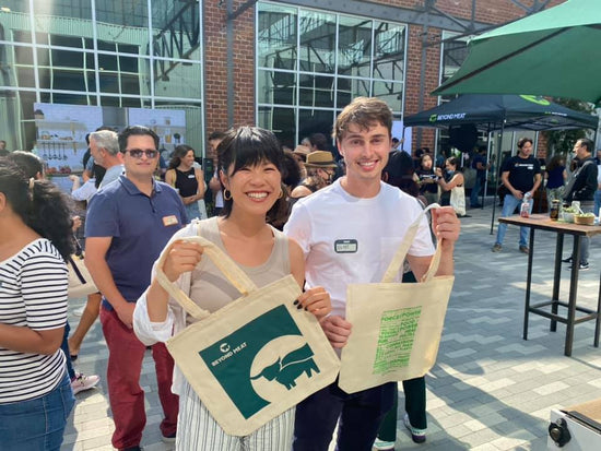 Two happy people at a live screen printing showing off their hot off the press tote bags at event in downtown los angeles.