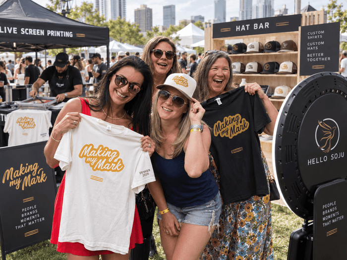 Guests posing with freshly printed shirts at a branded photo booth