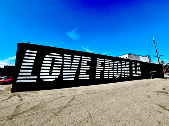 Large mural on the side of a building seen from the Santa Monica Freeway in Downtown Los Angeles.