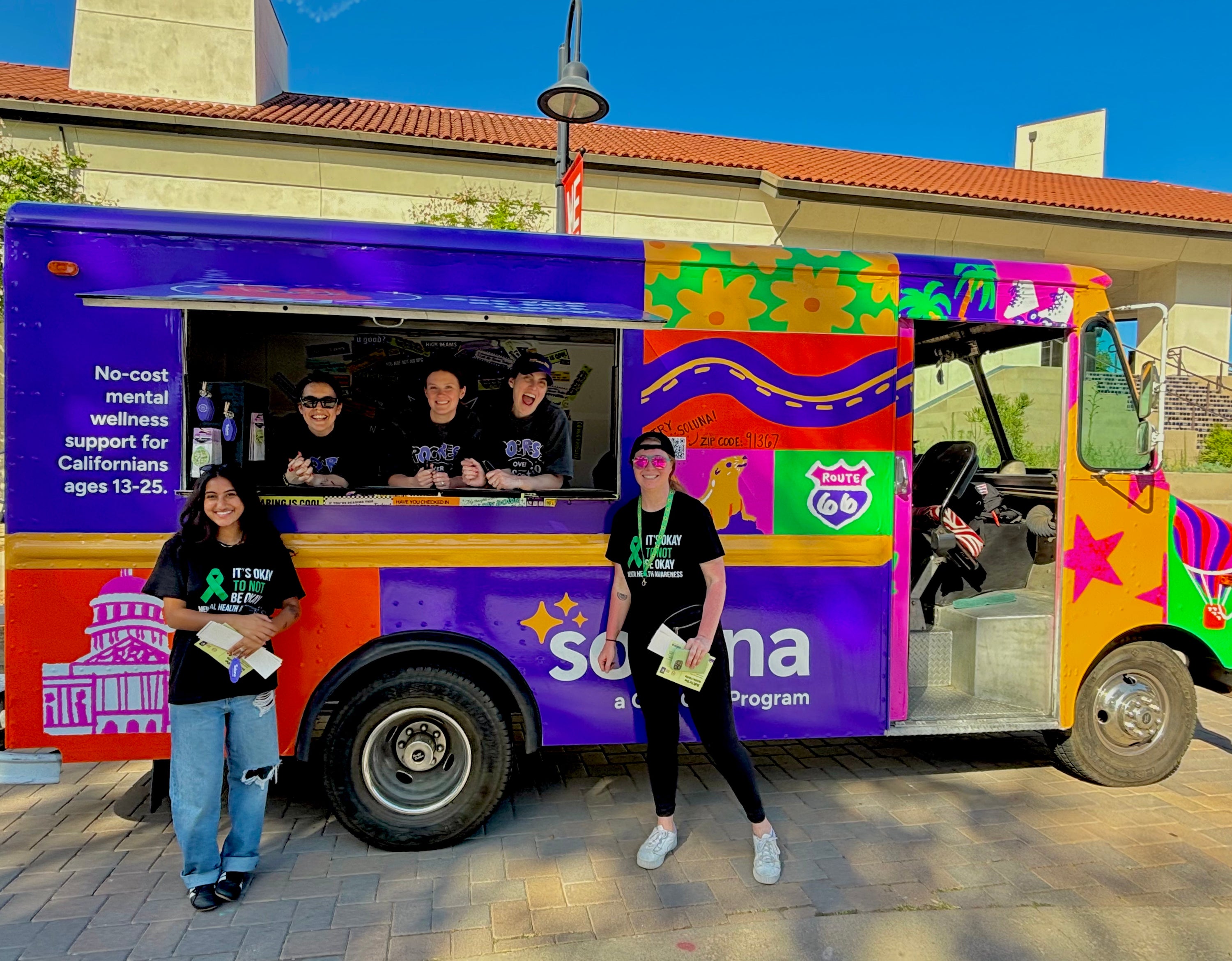A colorful mobile wellness truck mobile billboard truck advertising a mental health app for a multi-state mobile campaign with happy truck attendants around the truck.