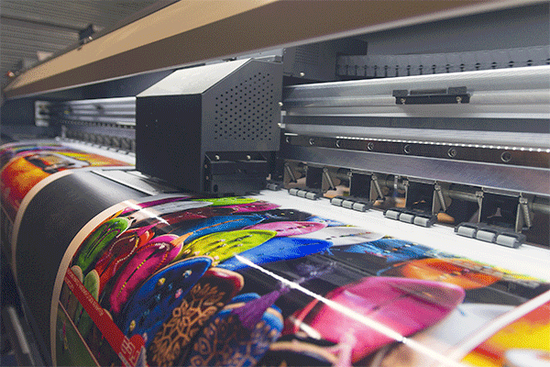 Large format machine printing high gloss, brightly colored flowers that will be vinyl wrapped on a vehicle in Denver, Colorado.