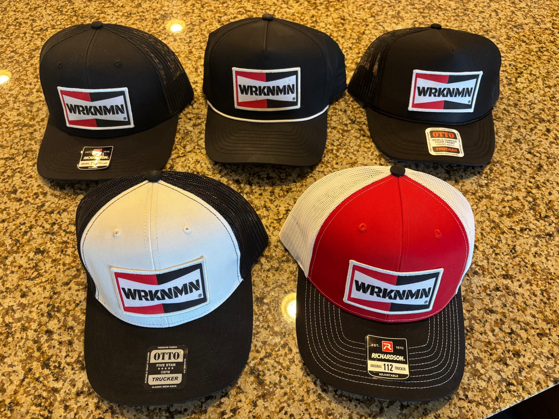 A collection of WRKNMN vintage retro trucker hats on display.